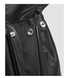 Black nylon handbag detail with durable metal snap buttons, fine stitching, and waterproof fabric.