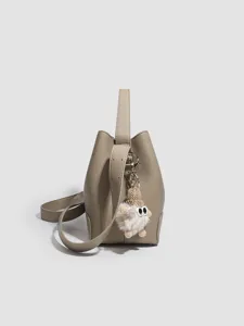 Stylish gray leather bucket bag with cute plush charm, versatile single shoulder & crossbody.