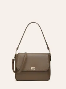 Detailed view of brown textured leather shoulder bag with gold-tone geometric metal clasp.
