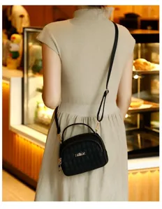 Stylish black quilted crossbody bag with top handle and strap for daily commuting and travel.