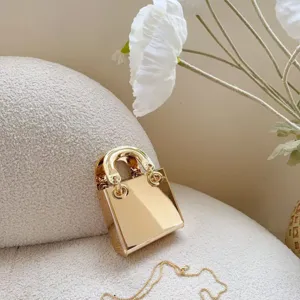Close-up van de metalen gouden mini vierkante tas detail met ketting en ronde handvat stijl.