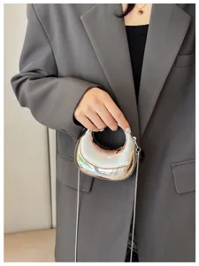 Metallic silver mini crossbody bag detail, modern fashion chic chain handbag accessory.