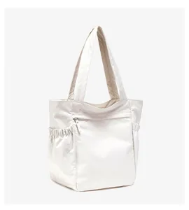 Detailopname van casual nylon tote tas met handige ritsvak aan de voorkant en zijvakken.