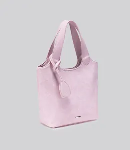 Nahaufnahme der rosa minimalistischen Tasche mit strukturierter Oberfläche und Griffen.