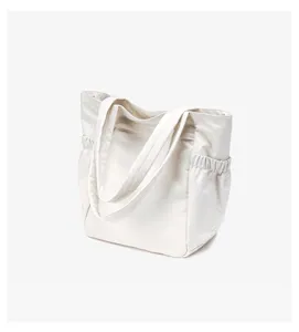 Nylon shopper tas detail met duurzame stiksels, zijzak en comfortabele schouderbanden.