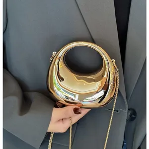 Metallic gold ring handle mini crossbody bag detail view, stylish metal chain clutch.