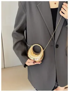 Detailed view of fashionable metallic mini crossbody bag with unique ring handle and chain strap.