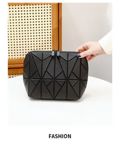 Dettagli della borsa cosmetica geometrica nera con design a pannelli triangolari e cerniera.