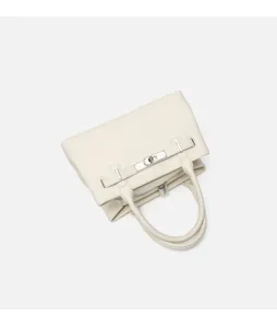 White top handle bag detail featuring pebbled leather and silver-tone hardware close up