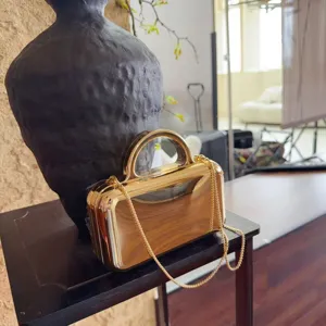 Detailed shot of the luxury gold mirror metallic evening clutch bag with chain strap and handle.