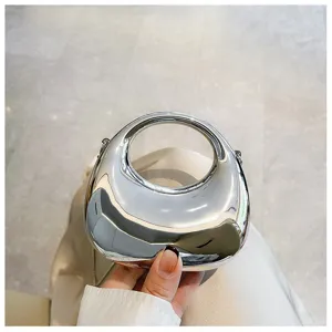Silver metallic mini handbag with round handle and chain, stylish crossbody bag for women.