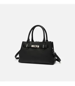 Black pebbled leather handbag detail showcasing metal turn lock clasp and durable handles.