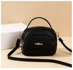 Detailed view of black quilted multi-layer shoulder bag with top handle and gold hardware.