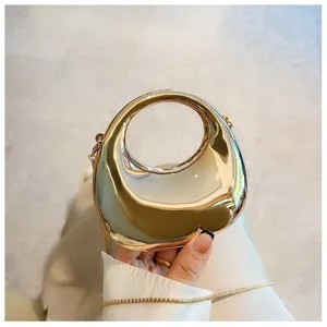 Detailed shot of metallic mini circular handle crossbody bag, modern stylish shiny accessory.