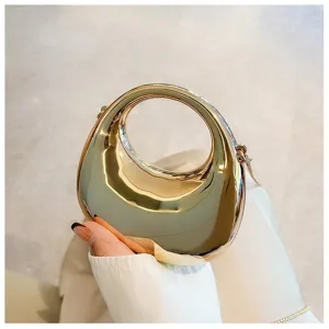 Close-up detail of the stylish metallic gold mini handbag featuring a unique round hollow handle.