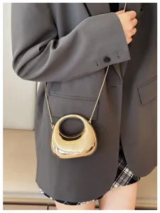 Mini metallic round handle crossbody bag for women, stylish chain handbag detail.