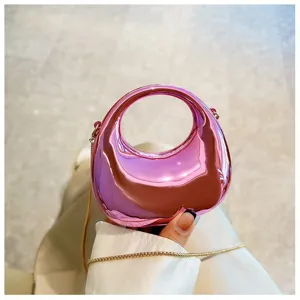 Shiny metallic pink mini handbag with round handle and gold chain crossbody strap detail.