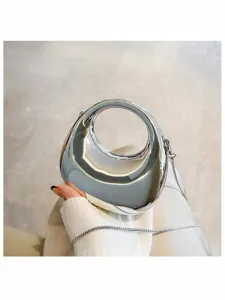 Shiny silver metallic mini handbag with circular handle and elegant chain strap for women.