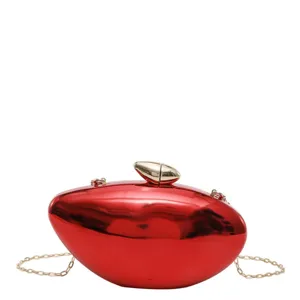 Dettaglio della pochette rigida rossa, borsa da sera metallica con catena dorata.