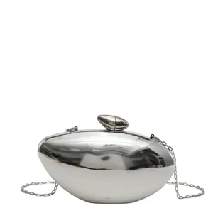 Dettaglio borsa da sera metallica a proiettile, pochette argento con catena donna.
