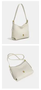 Close-up detail van de elegante witte hobo schoudertas met chique gouden logo accent.