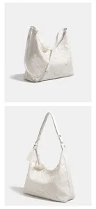 Detalle de bolso de hombro de cuero tejido blanco, elegante bolso cruzado con borla decorativa.