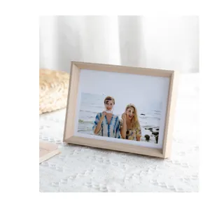 Wooden photo frame detail showcasing natural wood texture on a clean white fabric surface.