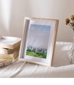 Wooden photo frame detail showing minimalist desktop styling with warm lighting and props.
