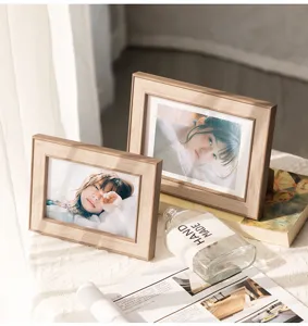 Close-up detail of minimalist wooden photo frame desk decor in warm lifestyle setting.