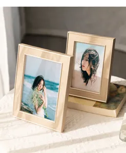 Detail shot of modern gold photo frames on table, elegant home decor setting for living room.