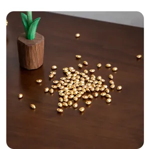 Close-up detail of miniature gold ingots decor displayed on a rustic wooden table.