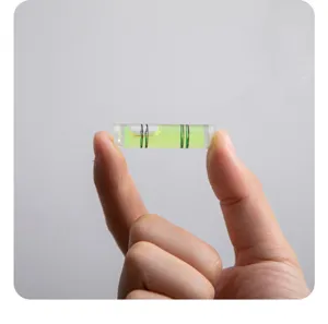 Primer plano detallado de un nivel de burbuja cilíndrico transparente de alta precisión.