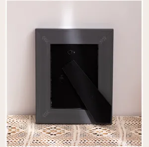 Back detail of dark grey retro picture frame with stand and hooks, simple home decor.