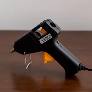 Electric hot melt glue gun 20W for DIY crafts and household repairs with metal stand.