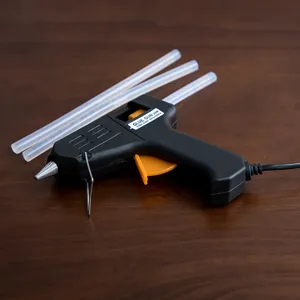 Electric hot melt glue gun with three transparent glue sticks for home and crafts use.