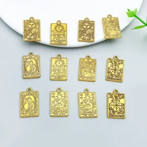 Closeup of antique gold alloy tarot card charms, double-sided mystical pendants for DIY jewelry.