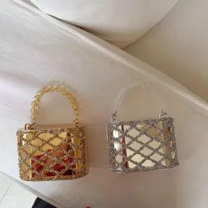 Gedetailleerde close-up van glanzende acryl strass avondtassen in goud en zilver.