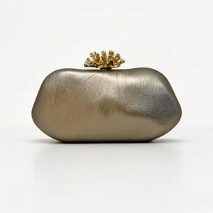 Goldene unregelmäßige Stein-Clutch Detailansicht, zeigt feine Metallic-Textur und Kronenverschluss.