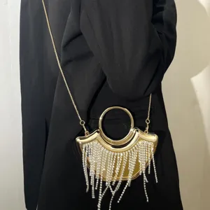 Détail de sac de soirée à franges en acrylique, avec strass étincelants et poignée en métal.