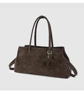 Gedetailleerd overzicht van de donkerbruine zachte lederen tote bag met sterhanger en riem.