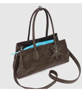Gedetailleerd weergave van bruine zachte leren tote tas met contrasterende blauwe voering en ster.