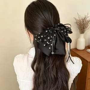 Detailansicht der schwarzen Blumen Schleife Haarklammer mit Perlen Anhänger für elegantes Haar.