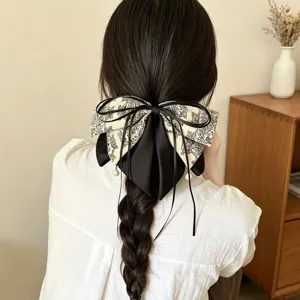 Detailansicht der eleganten Paisley Schleifen Haarklammer mit schwarzem Band und Perlen für Frauen.