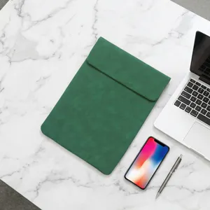 Green leather laptop sleeve detail view on marble desk with device props, sleek protective case.