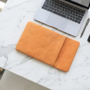 Detailed view of the lightweight tan laptop sleeve on marble desk, showing texture and design.