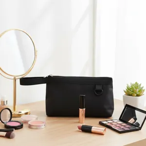 Vista detallada de un neceser de maquillaje negro con asa y gran espacio de almacenamiento.