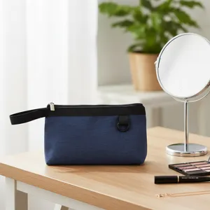 Vista detallada de una elegante bolsa cosmética azul oscuro con asa para uso diario en viaje.