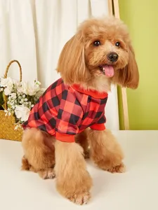 Gros plan detail d'un chien mignon portant un pull polaire a carreaux rouge et noir.