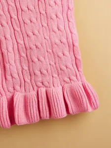 Pink cable knit pet sweater detail showing soft wool fabric and cute ruffled hem design.