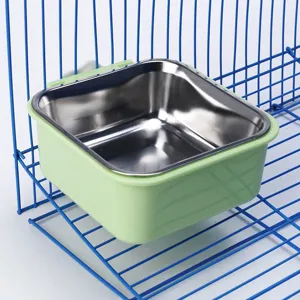 Stainless steel pet hanging bowl with green plastic holder, anti-tip cage feeder detail view.